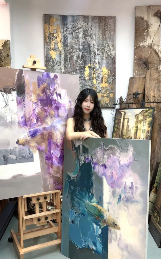 蓝绿和淡紫色抽象鱼形作品在工作室中展示
